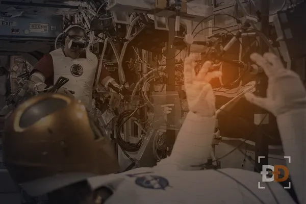 An astronaut wearing a virtual reality headset controls the Robonaut 2 humanoid robot aboard the International Space Station.
